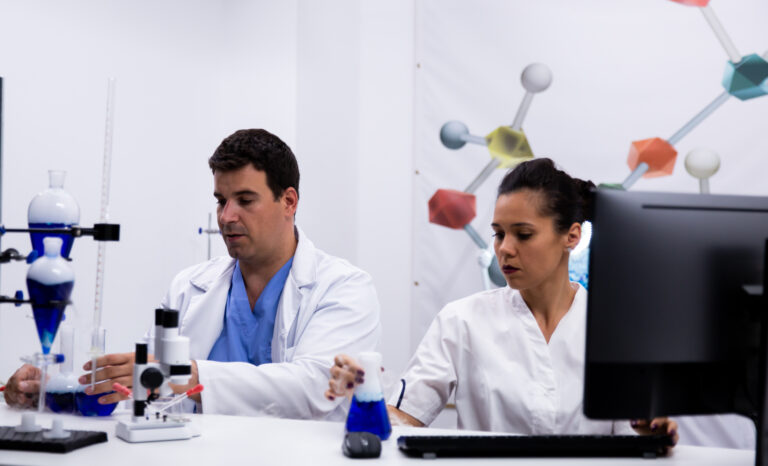 Équipe de chercheurs portant une blouse dans un laboratoire de recherche moderne. PC en laboratoire.